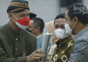 MENYERAHKAN: Ganjar Pranowo saat menyerahkan penghargaan pada Wali Kota Semarang Hendrar Prihadi di Gedung Gradhika Bhakti Praja. (Adimungkas/Lingkarjateng.id)