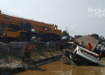 NYUNGSEP: Truk trailer bermuatan pakan ternak tercebur di Sungai Pantura Karangsuno Kendal, Rabu (13/4). (Unggul Priambodo/Lingkarjateng.id)