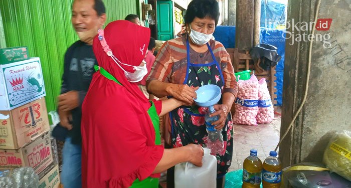 JUAL BELI: Pedagang melayani pembeli minyak goreng di Pasar Induk Purwodadi, Kabupaten Grobogan, baru-baru ini. (Muhamad Ansori/Lingkarjateng.id)