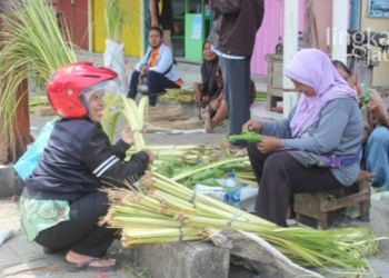 MENJUAL: Rasmi, penjual janur yang sedang melayani pembeli di Pasar Rakyat Sidomakmur Blora pada Rabu (04/05). (Lilik Yuliantoro/Lingkarjateng.id)