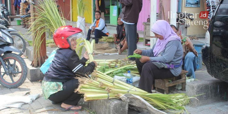 MENJUAL: Rasmi, penjual janur yang sedang melayani pembeli di Pasar Rakyat Sidomakmur Blora pada Rabu (04/05). (Lilik Yuliantoro/Lingkarjateng.id)