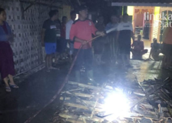 MEMADAMKAN API: Personel pemadam kebakaran dibantu warga sekitar memadamkan api yang membakar sebuah rumah di Desa Agungmulyo, Kecamatan Juwana, Pati pada Kamis malam (26/05). (Facebook Pemadam Kebakaran/Lingkarjateng.id)