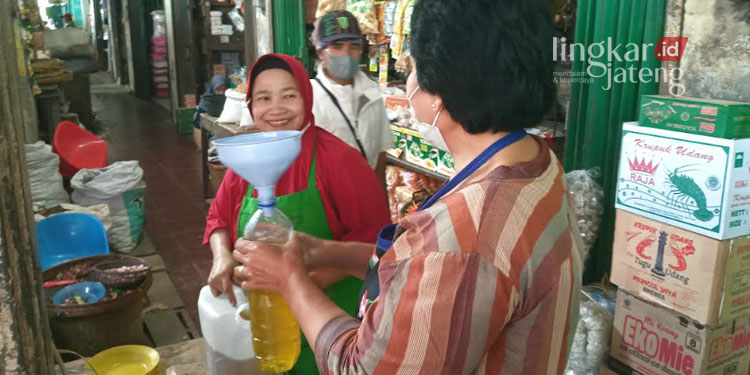 MEMBELI: Warga membeli minyak goreng curah di salah satu toko di Kabupaten Grobogan. (Muhamad Ansori/Lingkarjateng.id)