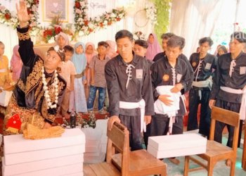 ATRAKSI: Bukhori, sosok pengantin melakukan atraksi memecah batako saat resepsi pernikahan di rumahnya pada Minggu, 17 Juli 2022. (Muhamad Ansori/Lingkarjateng.id)