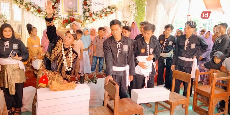 ATRAKSI: Bukhori, sosok pengantin melakukan atraksi memecah batako saat resepsi pernikahan di rumahnya pada Minggu, 17 Juli 2022. (Muhamad Ansori/Lingkarjateng.id)