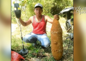 BERPOSE: Warga Desa Patalan, Kecamatan Blora, Kabupaten Blora, Kumaidi (36) berfoto dengan bom temuannya dan alat metal detector. (Lilik Yuliantoro/Lingkarjateng.id)