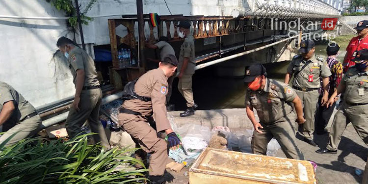 MEMBONGKAR: Satpol PP Semarang membongkar hunian liar di kolong jembatan Banjir Kanal Barat Semarang. (Adimungkas/Lingkarjateng.id)