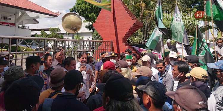 AKSI TUNTUTAN: Ratusan massa aksi melakukan demo di depan Gerbang DPRD Kabupaten Kudus, Senin, 8 Agustus 2022. (Hasyim Asnawi/Lingkarjetang.id)