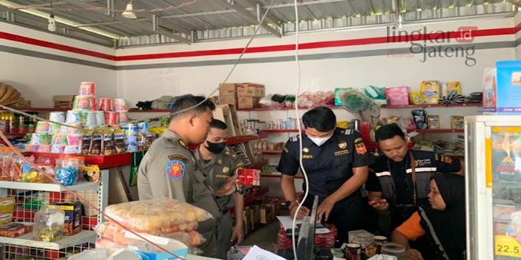 MENCATAT: Anggota Satpol PP Pati memeriksa dan mencatat penemuan rokok ilegal dalam Operasi Pasar Barang Kena Cukai. (Aziz Afifi/Koran Lingkar)