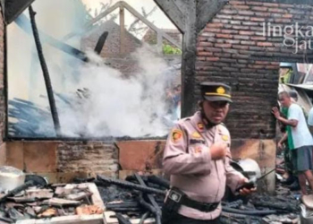 EVAKUASI: Petugas pemadam kebakaran dibantu warga sekitar saat memadamkan api yang membakar rumah milik Tiarsih, warga Desa Tlogorejo, Kecamatan Tlogowungu, Kabupaten Pati pada Senin, 1 Agustus 2022. (Arif Febriyanto/Lingkarjateng.id)