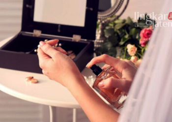 ILUSTRASI: Seorang wanita menyemprotkan parfum pada titik nadi di tangan. (Freepik @New Africa/Lingkarjateng.id)