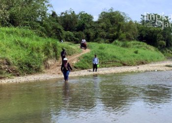 MENYEBRANG: Sejumlah warga Dusun Tapak Timur, Desa Kedunggading Kecamatan Ringinarum, Kabupaten Kendal harus menyebrang sungai menuju Balai Desa setempat. (Arvian Maulana/Lingkarjateng.id)