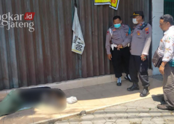 EVAKUASI: Petugas Polsek Cepiring mengevakuasi mayat laki-laki tanpa identitas yang di depan sebuah toko di pinggir Jalan Pantura Cepiring, Kabupaten Kendal. (Arvian Maulana/Lingkarjateng.id)