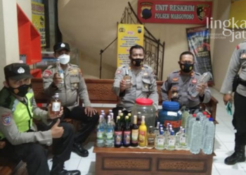 MENGAMANKAN: Petugas Polsek Margoyoso berhasil mengamankan puluhan botol minuman keras hasil operasi di dua warung milik warga Desa Ngemplak Kidul, Kecamatan Margoyoso, Kabupaten Pati. (Arif Febriyanto/Lingkarjateng.id)