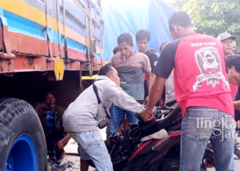 RUSAK PARAH: Proses evakuasi motor yang terjepit di antara roda belakang truk tronton di Jalan Purwodadi-Blora tepatnya Desa Getasrejo, Tawangharjo, Kabupaten Grobogan pada Senin, 26 September 2022. (Muhamad Ansori/Lingkarjateng.id)