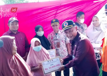 SIMBOLIS: PJ Bupati Pati, Henggar Budi Anggoro saat menyerahkan BBT kepada korban banjir bandang di Kecamatan Margoyoso pada Kamis, 22 September 2022. (Arif Febriyanto/Lingkarjateng.id)