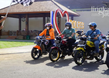 SIMBOLIS: Pj Bupati Jepara, Edy Supriyanta mengibarkan bendera tanda dimulainya acara tur bersama pecinta motor 2-tak. (Muslichul Basid/Lingkarjateng.id)