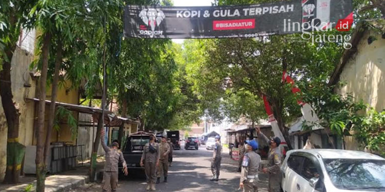 MENERTIBKAN: Anggota Satpol PP Pati melakukan pencopotan banner yang tak sesuai aturan di Kabupaten Pati pada Senin, 12 September 2022. (Istimewa/Lingkarjateng.id)