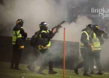 MENEMBAK: Aparat keamanan menembakkan gas air mata untuk menghalau suporter yang masuk ke lapangan usai pertandingan BRI Liga 1 antara Arema melawan Persebaya di Stadion Kanjuruhan, Malang, Jawa Timur pada Sabtu, 1 Oktober 2022 malam. (Istimewa/Lingkarjateng.id)