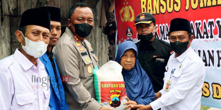 SIMBOLIS: Kapolres Demak, AKBP Budi Adhy Buono, menyerahkan bantuan kepada warga Desa Margolinduk, Kecamatan Bonang, Kabupaten Demak. (Tomi Budiantoro/Lingkarjateng.id)
