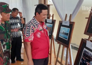 MENINJAU: Kepala Dinas Pariwisata dan Kebudayaan Jepara, Zamroni Lestiaza melihat foto zaman dulu Jepara di Museum R.A Kartini. (Muslichul Basid/Lingkarjateng.id)