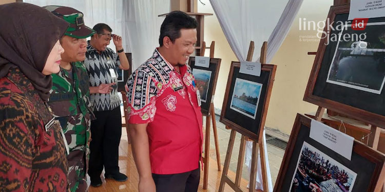 MENINJAU: Kepala Dinas Pariwisata dan Kebudayaan Jepara, Zamroni Lestiaza melihat foto zaman dulu Jepara di Museum R.A Kartini. (Muslichul Basid/Lingkarjateng.id)
