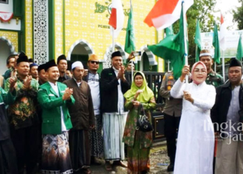 SEMARAK: Bupati Grobogan, Sri Sumarni (membawa tongkat bendera merah putih) saat melepas rombongan ziarah di depan kantor PCNU Kabupaten Grobogan pada Minggu, 16 Oktober 2022. (Muhamad Ansori/Lingkarjateng.id)