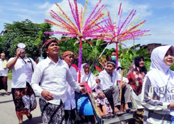 ANGON PUTU: Mbah Umiah (94), Dukuh Madaran RT 4 RW 1 Desa Mijen, Kecamatah Kaliwungu, Kabupaten Kudus membawa cambuk sambil melakukan tradisi angon putu keliling desa pada Sabtu, 8 Oktober 2022. (Nisa Hafizhotus S/Lingkarjateng.id)