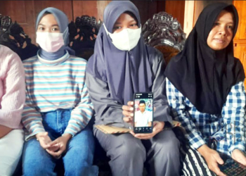 POTRET: Eka Dea Mawardani (membawa handphone), anak dari Mundakir yang merupakan korban tenggelamnya kapal kargo, didampingi ibundanya Suhartini saat ditemui di kediamannya di Desa Poncorejo, Kecamatan Gemuh, Kabupaten Kendal pada Minggu, 6 November 2022. (Arvian Maulana/Lingkarjateng.id)