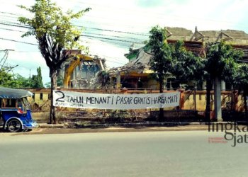 ASPIRASI: Warga menyampaikan aspirasi melalui spanduk bertuliskan "2 tahun menanti pasar gratis harga mati" yang dipasang di depan Pasar Weleri Kendal pada Selasa, 15 November 2022. (Arvian Maulana/Lingkarjateng.id)