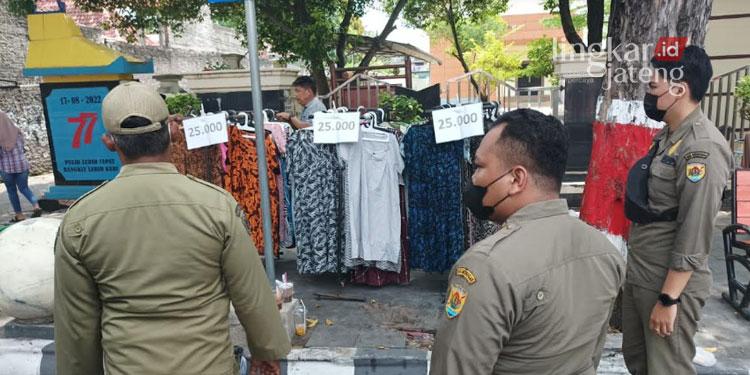 MENERTIBKAN: Petugas Satpol PP melakukan penertiban pedagang di Jalan R. Suprapto pada Minggu, 6 November 2022. (Muhamad Ansori/Lingkarjateng.id)