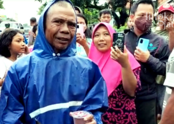 SEMPAT PANIK: Supinto (pakai jas hujan), warga Desa Kedungsari, Kecamatan Tayu, Kabupaten Pati yang diduga terseret arus usai hujan pada Kamis, 24 November 2022. (Istimewa/Lingkarjateng.id)