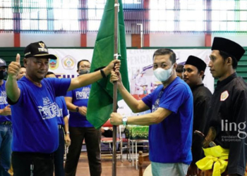 SIMBOLIS: Pj Bupati Pati, Henggar Budi Anggoro (kiri, bertopi) saat menyerahkan bendera pataka IPSI kepada Ketua IPSI Pati, Tris Irawan sebagai simbol dibukanya Kejuaraan Pencak Silat Pati Open 2022 pada Senin, 14 November 2022. (Istimewa/Lingkarjateng.id)