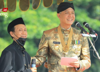 MEMBERI APRESIASI: Subari, petani asal Kabupaten Kendal yang viral karena hibahkan lahan untuk dijadikan embung, dihadirkan oleh Gubernur Jawa Tengah, Ganjar Pranowo di Upacara Peringatan Hari Pahlawan belum lama ini. (Dok. Humas Pemprov Jateng/Lingkarjateng.id)
