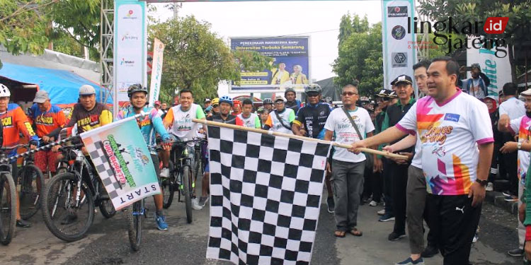 SIMBOLIS: Bupati Blora, Arief Rohman bersama pihak Luwak White Koffie secara simbolis melepas peserta Gowes dengan mengibarkan bendera pada Minggu, 4 Desember 2022. (Istimewa/Lingkarjateng.id)