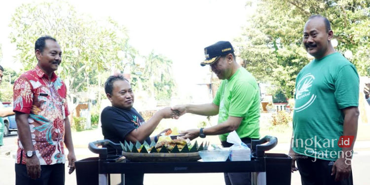 SIMBOLIS: Pj Bupati Jepara, Edy Supriyanta memberikan potongan tumpeng kepada salah satu penyandang disabilitas. (Muslichul Basid/Lingkarjateng.id)