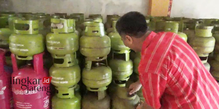 MENGECEK: Pemilik Agen Gas LPG di Kecamatan Ngaliyan, Kota Semarang sedang menata gas LPG 3 kilogram. (Adimungkas/Lingkarjateng.id)