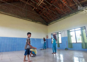 GOTONG ROYONG: Guru dan murid SD 3 Glagahwaru, Kecamatan Undaan, Kabupaten Kudus membersihkan material plafon yang runtuh diterjang angin kencang. (Ihza Fajar/Lingkarjateng.id)