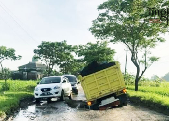 TERPEROSOK: Sebuah truk terperosok dan terjebak di lubang Jalan Winong-Gabus, Kabupaten Pati pada Kamis, 12 Januari 2022 pagi. (Istimewa/Lingkarjateng.id)