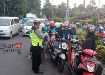 KENA TILANG: Petugas Satlantas Polresta Pati menilang pemotor yang nekat terobos jalur cepat. (Istimewa/Lingkarjateng.id)