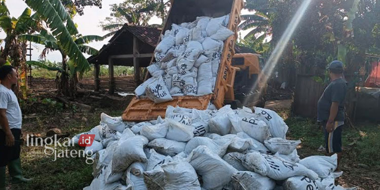 BONGKAR MUAT: Sebanyak 600 karung berisi limbah FABA diturunkan dari truk untuk penanggulangan banjir sementara di Desa Sowan Kidul, Kecamatan Kedung, Kabupaten Jepara. (Tomi Budianto/Lingkarjateng.id)