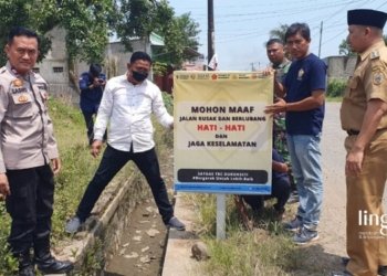 PASANG RAMBU JALAN: Ketua TRC Dukuhseti yang juga Camat Dukuhseti, Agus Sunarko (paling kanan baju khaki) memasang rambu di titik jalan rusak ruas jalan utama Tayu-Puncel pada Senin, 20 Maret 2023. (Istimewa/Lingkarjateng.id)