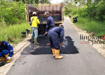 PERBAIKAN JALAN: Pekerja dari CV Arum Jaya bahu-membahu memperbaiki jalan yang rusak di jalan Temengeng-Pasar Sore, Kabupaten Blora pada Rabu, 29 Maret 2023. (Hanafi/Lingkarjateng.id)