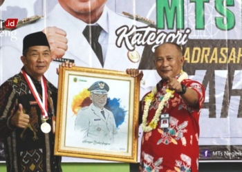 SIMBOLIS: Pj Bupati Pati Henggar Budi Anggoro (kanan) menerima cinderamata dari Kepala MTsN 1 Pati, Ali Musyafak (kiri) pada puncak peringatan hari lahir ke-43 MTs Negeri 1 Pati pada Sabtu, 18 Maret 2023. (Istimewa/Lingkarjateng.id)
