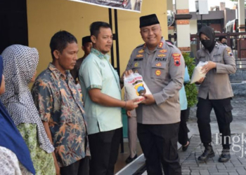 SIMBOLIS: Kapolres Demak, AKBP Budi Adhy Buono menyerahkan zakat fitrah kepada warga pada Selasa, 18 April 2023. (Muhammad Burhanuddin Aslam/Lingkarjateng.id)