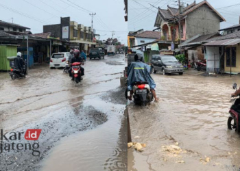 ILUSTRASI: Kondisi jalan rusak tergenang banjir di Jalan Purwogondo, Kecamatan Kalinyamatan, Kabupaten Jepara beberapa waktu lalu. (Burhan/Lingkarjateng.id)