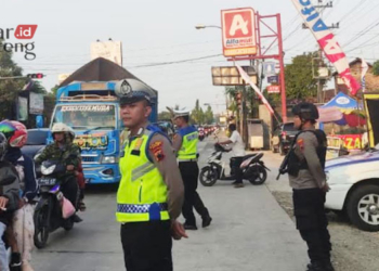 PENGAMANAN: Personel Polres Kudus mengamankan kelancaran lalu lintas di Jalur Pantura Timur Kudus, pada Selasa, 25 April 2023. (Ihza Fajar/Lingkarjateng.id)