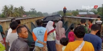 EVAKUASI: Warga menyaksikan sebuah mobil Fortuner yang melintang di atas viaduk setelah menyelonong masuk ke jalur rel KA Sumpiuh, Kabupaten Banyumas, Rabu, 19 April 2023. (Istimewa/Lingkarjateng.id)