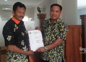 SIMBOLIS: Kades Kalinanas, Jani (kiri), menyerahkan surat pengunduran diri untuk maju Pileg 2024. (Hanafi/Lingkarjateng.id)