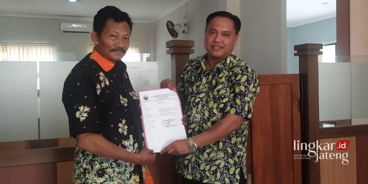 SIMBOLIS: Kades Kalinanas, Jani (kiri), menyerahkan surat pengunduran diri untuk maju Pileg 2024. (Hanafi/Lingkarjateng.id)